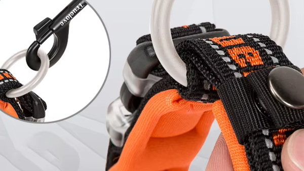 Detalhe da argola de metal de um peitoral laranja e preto
