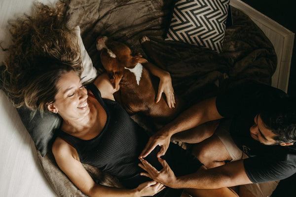 Mulher deitada na cama com cachorro